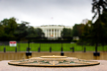 Zero Milestone in Washington D.C. with blurred White House in the background