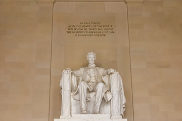 Statue of Abraham Lincoln inside Lincoln Memorial in Washington D.C. from frontal view with text visible above the statue