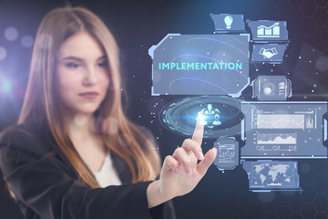 The concept of business, technology, the Internet and the network. A young entrepreneur working on a virtual screen of the future and sees the inscription: Implementation
