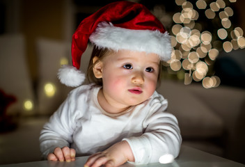 Fototapeta na wymiar Toddler boy playing with a Santa hat around Christmas time