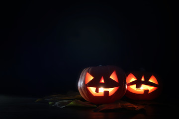 Halloween holiday concept. Pumpkins over wooden table at night scary, haunted and misty forest.