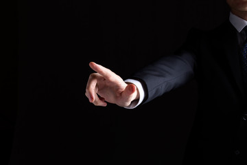 Man in a suit pointing or pressing something on black background