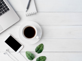 top view of office desk workspace with coffee cup, notebook, plastic plant, smartphone and keyboard on white background, graphic designer, Creative Designer concept.
