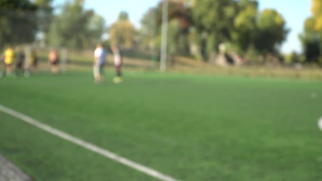 Teens boys plays soccer on football field, defocused shooting, gdpr concept