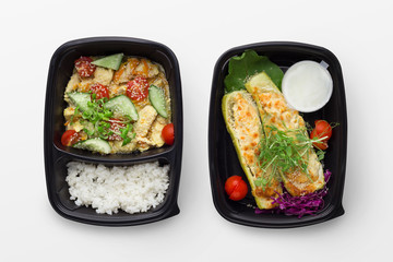 Set of take away difhes in black containers
