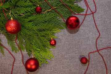 New Year's, Christmas red decorations and green coniferous branches on a gray background