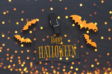Halloween holiday minimal top view image of letter with text HAPPY HALLOWEEN over wooden background. Card and invitation concept.