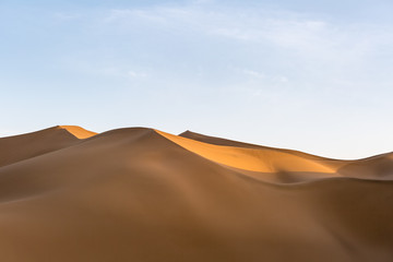 Fototapeta na wymiar Sand dunes illuminated by the setting sun