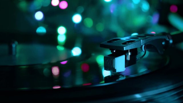 Vinyl record player. Needle drops. Night cold neon lights background.