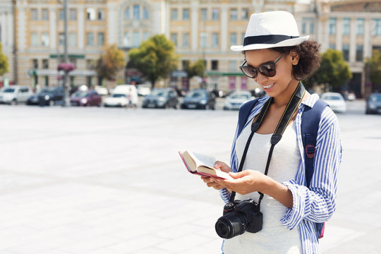 African-american Tourist Reading Guide Book In City