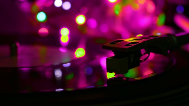 Vinyl recrod played spinning disc. Atmosphere cyan light on a background.
