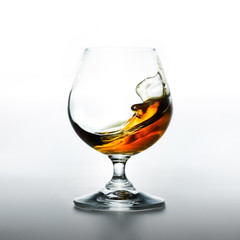 Cognac glass with splashing brandy inside