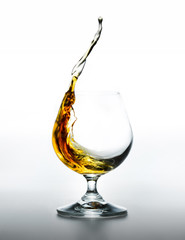 Cognac glass with splashing brandy inside