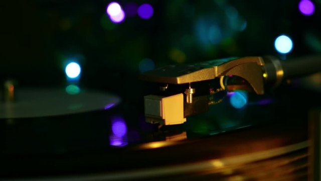 Vinyl recrod played spinning disc. Atmosphere moody cyan light on a background.
