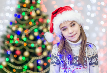 happy little girl in red santa christmas hat. Space for text