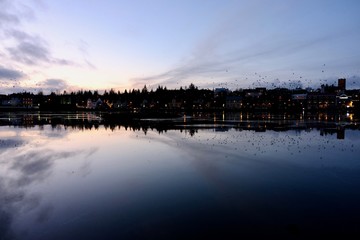 Obraz premium The buildings were reflected in the frozen lake during dusk