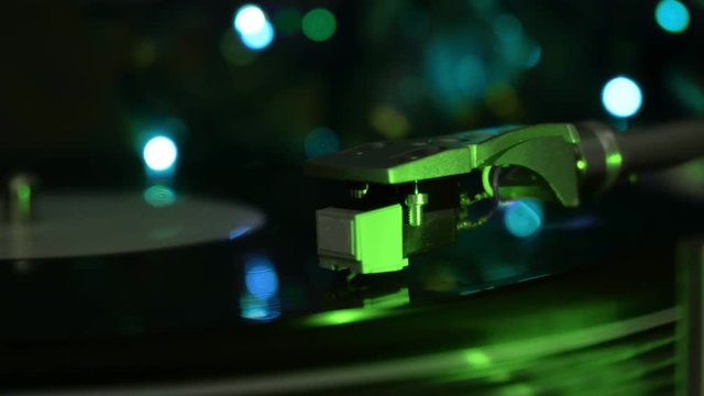 Vinyl turntable record player stylusdrop. Acid green light background.
