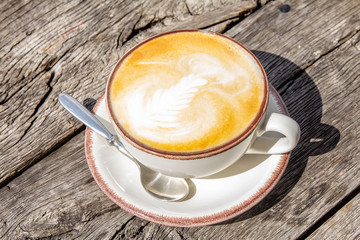Good morning with aromatic coffee cappuccino in white cup with on table wooden in cafe
