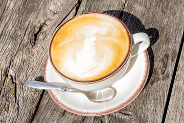 Good morning with aromatic coffee cappuccino in white cup with on table wooden in cafe