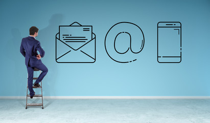Businessman watching contact icon on a wall