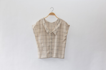 scotch colour blouse is clothes hanger on white background.