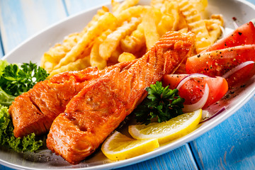 Fried salmon, French fries and vegetables