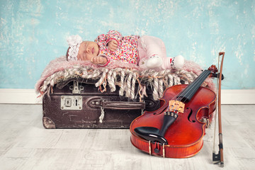Baby schläft auf Koffer mit Geige - Newborn