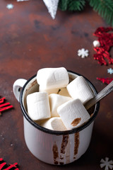 Winter hot drink close up. Hot chocolate or cocoa with marshmallow and spices on dark stone background.