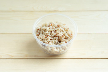 Fototapeta na wymiar Organic brown rice in plastic bowl