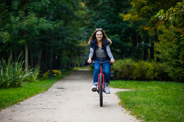 Fototapeta premium Urban biking - woman riding bike in city park