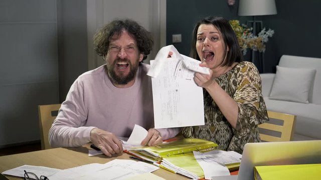 Man and woman screaming desperate about bills and taxes slow motion