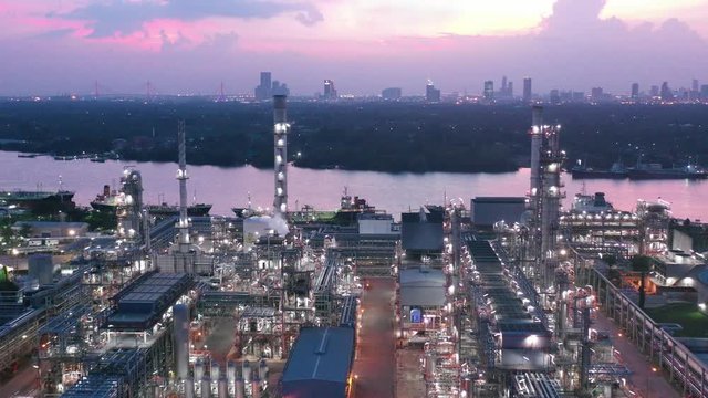 Video Industrial view at oil refinery plant form industry zone with sunrise and cloudy sky.Oil refinery and Petrochemical plant at dusk,Thailand. Aerial view