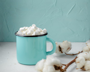 Mug of cocoa with marshmallows and winter decor
