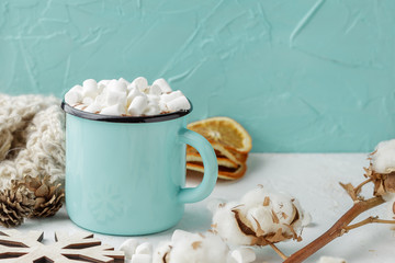 Mug of cocoa with marshmallows and winter decor