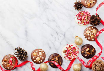 Chocolate mediants with Christmas ribbon. Marble background. Copy space. Top view.