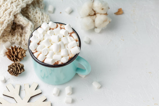 Mug of cocoa with marshmallows and winter decor