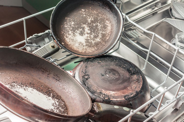 Dirty pans lie in the dishwasher for washing