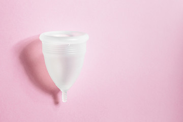 Menstrual cup on pink background, feminine hygiene