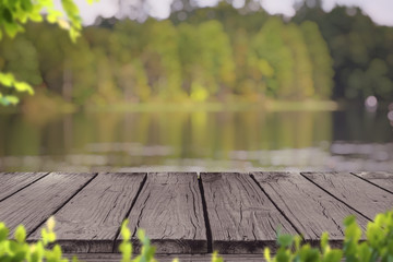 Old wood deck with blur background of lake and forest in early Autumn , for display or montage your...