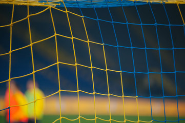 Soccer net with a blurred background. At the stadium, in the spotlight. Football game moment.