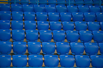 Naklejka premium Niebieskie puste miejsca na stadionie piłkarskim. Żółte schody z kilkoma sektorami.