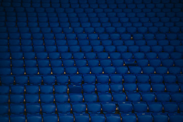 Blue empty seats at a football stadium. Yellow stairs with a number of sectors.