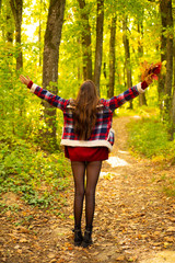 Freedom Concept. Outdoor fashion photo of young beautiful lady surrounded autumn leaves. Romantic Autumn Woman Model. Autumn Beauty. Portrait of beautiful caucasian woman walking outdoors. Hello
