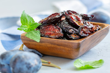 Spicy dried plums in a wooden bowl.