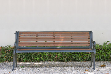 empty wooden bench with white copy space wall as background.