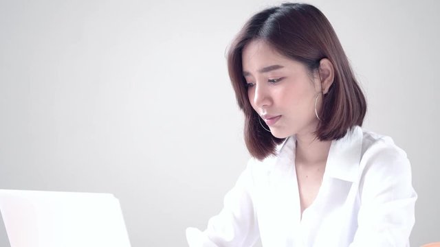 Young Asian woman working on computer and get a good result then happy