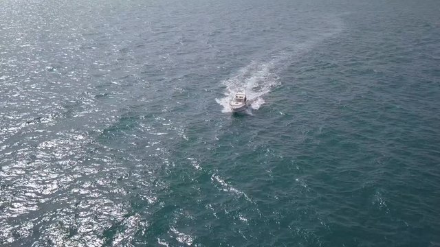 Following a speedboat roaring across the Mediterranean Sea - Top down aerial footage.