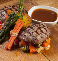 grilled beef steak on wooden board with sauce