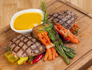 grilled beef steak on wooden board with sauce