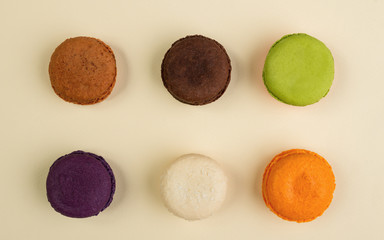 Six different Macarons flavors on beige background